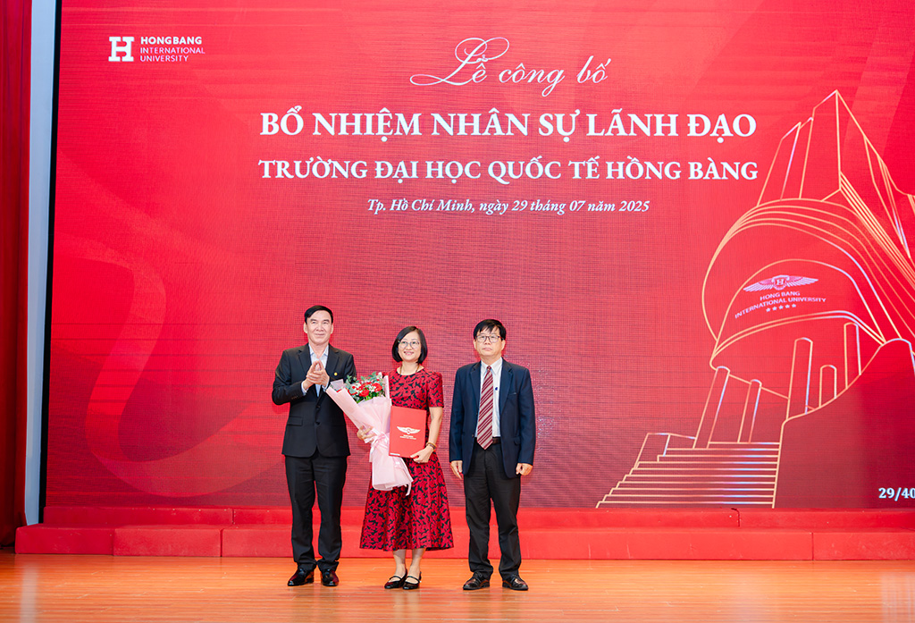 PGS.TS PGS.TS Nguyễn Bá Hoàng - Chủ tịch Hội đồng trường (bìa phải) và GS.TS.BS Phạm Văn Lình (bìa trái) trao quyết định và tặng hoa chúc mừng tân Phó Hiệu trưởng Lương Thị Kim Chi