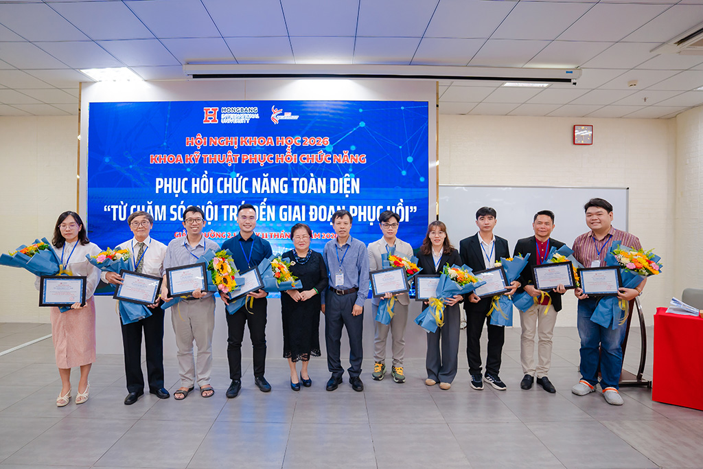 Đại diện Ban Tổ chức trao hoa tri ân các báo cáo viên tham gia Hội nghị khoa học năm 2026 của Khoa Kỹ thuật Phục hồi chức năng.